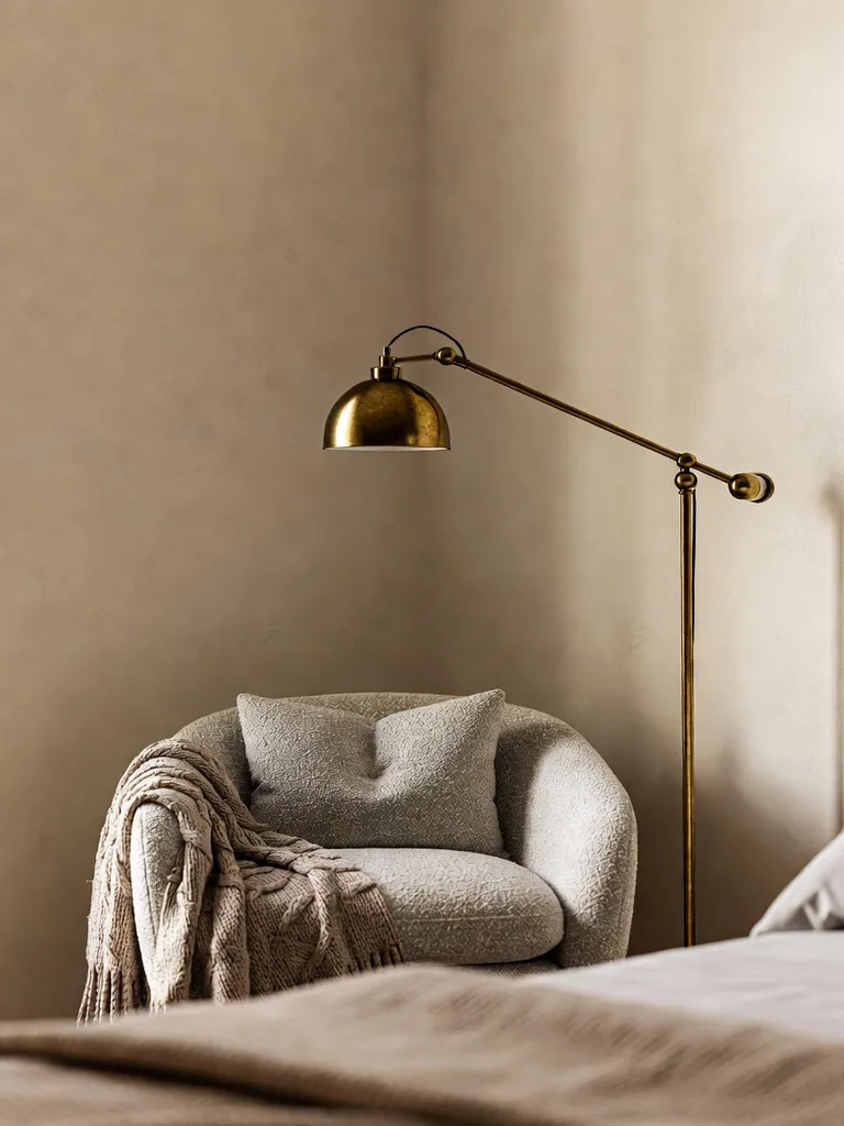 A cozy reading nook in a bedroom featuring a plush armchair, soft throw blanket, and ambient lighting, perfect for relaxat...